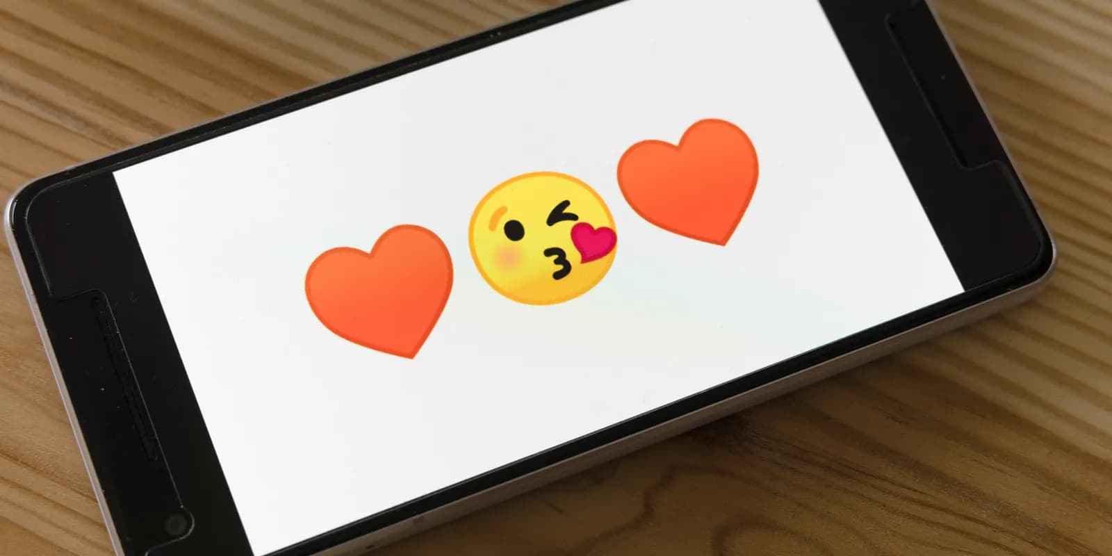 Global audience using smartphones with colorful emoji icons floating above their screens for digital marketing