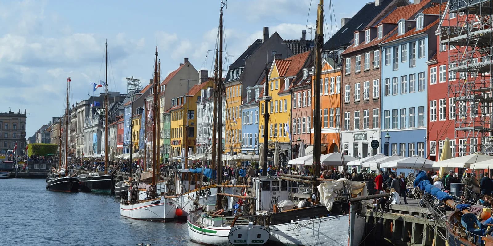 Diverse national flags of Nordic countries fluttering against a clear blue sky, representing Scandinavian language markets.