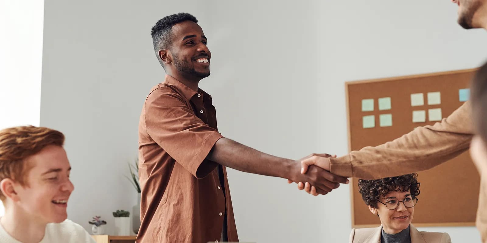 Two corporate business professionals shaking hands to finalize a strategic translation partnership agreement.